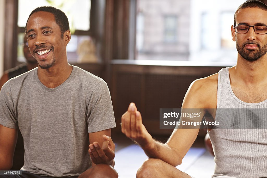 Men meditating in yoga class