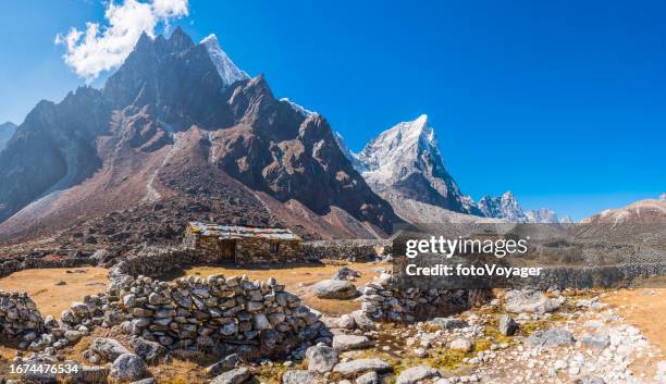himalayan peaks overlooking mountain huts for yaks and drivers nepal - namche bazaar stock pictures, royalty-free photos & images