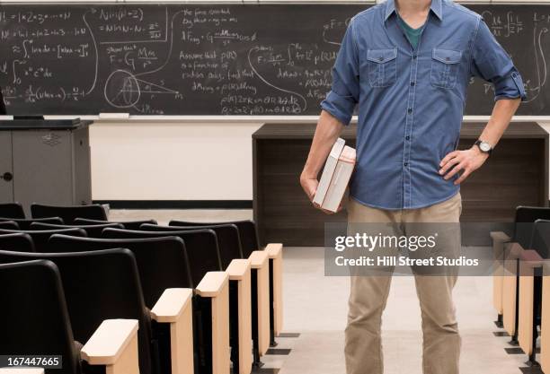 caucasian student standing in classroom - returning book stock pictures, royalty-free photos & images