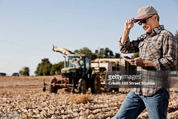 hispanic farmer using cell phone in crop field - answering stock-fotos und bilder