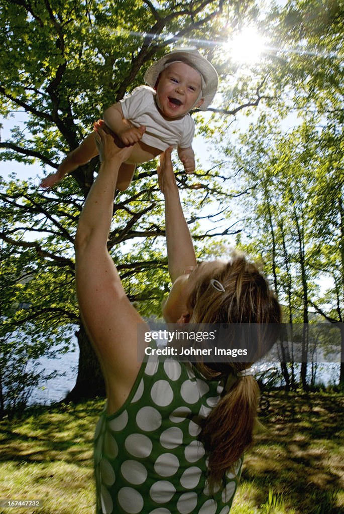 Mother lifting a baby up in the air, Sweden.