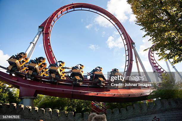 low angle view of people at rollercoaster - theme park ride stock pictures, royalty-free photos & images