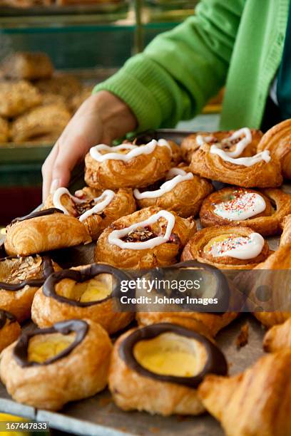 woman holding danish pastries in bakery - danish pastry stock pictures, royalty-free photos & images