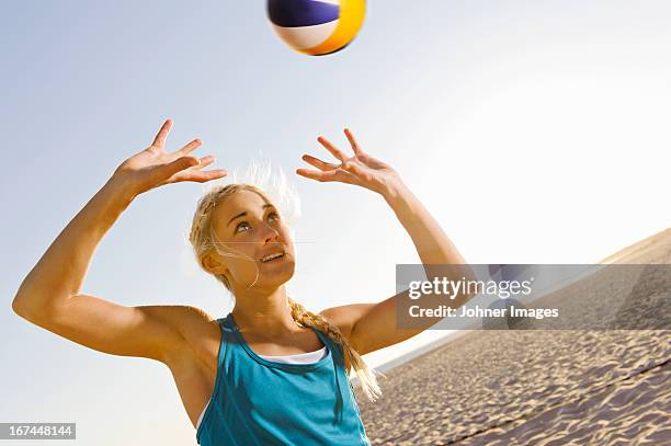 young woman playing beach volleyball - womens beach volleyball stock-fotos und bilder