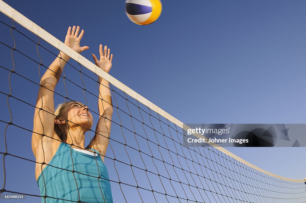 Young woman playing beach volleyball