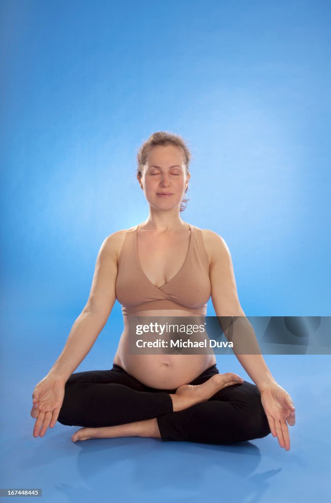 Studio shot of a pregnant woman doing yoga