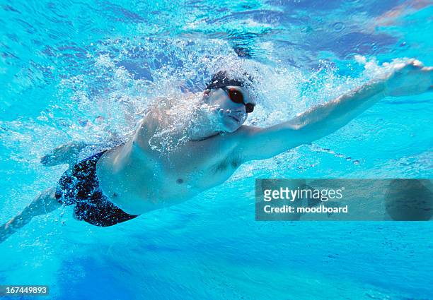 underwater shot of professional male athlete swimming in pool - aquatic sport stockfoto's en -beelden