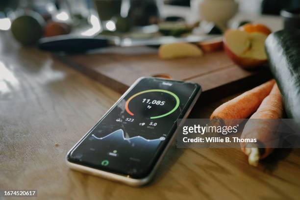 close up of smartphone lying next to vegetable while displaying health app - metabolism stock pictures, royalty-free photos & images
