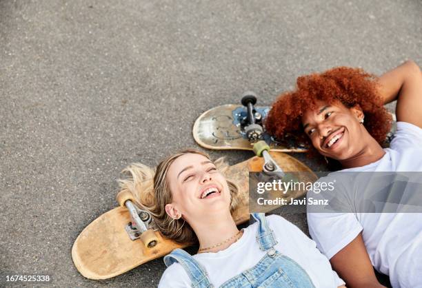 vista superior de jóvenes amigos patinadores hipster felices tirados en una carretera - monopatín artículos deportivos fotografías e imágenes de stock