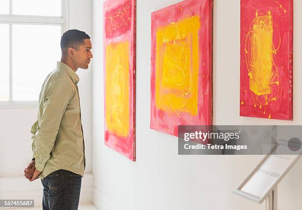 man watching paintings in modern art gallery - 藝術博物館 個照片及圖片檔