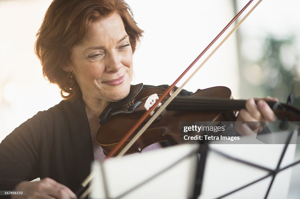 USA, New Jersey, Jersey City, Senior woman playing violin