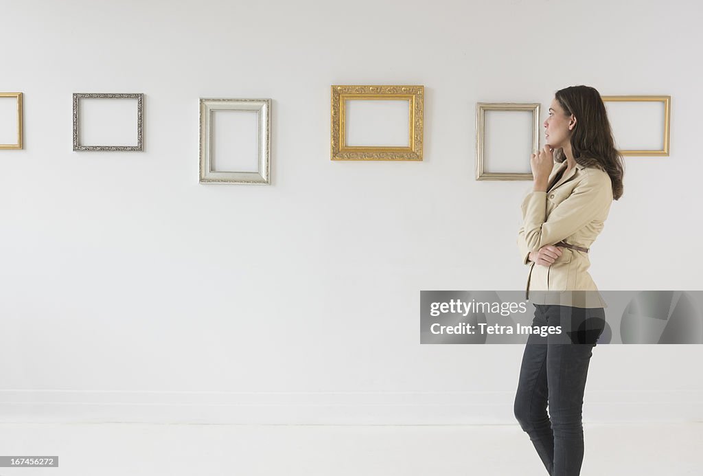 USA, New Jersey, Jersey City, Woman looking at blank pictures in art gallery