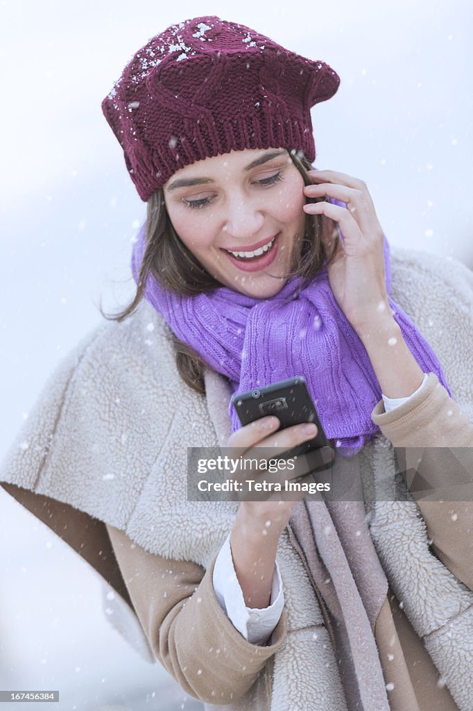 USA, New Jersey, Jersey City, Young woman in wearing warm clothes and using mobile phone