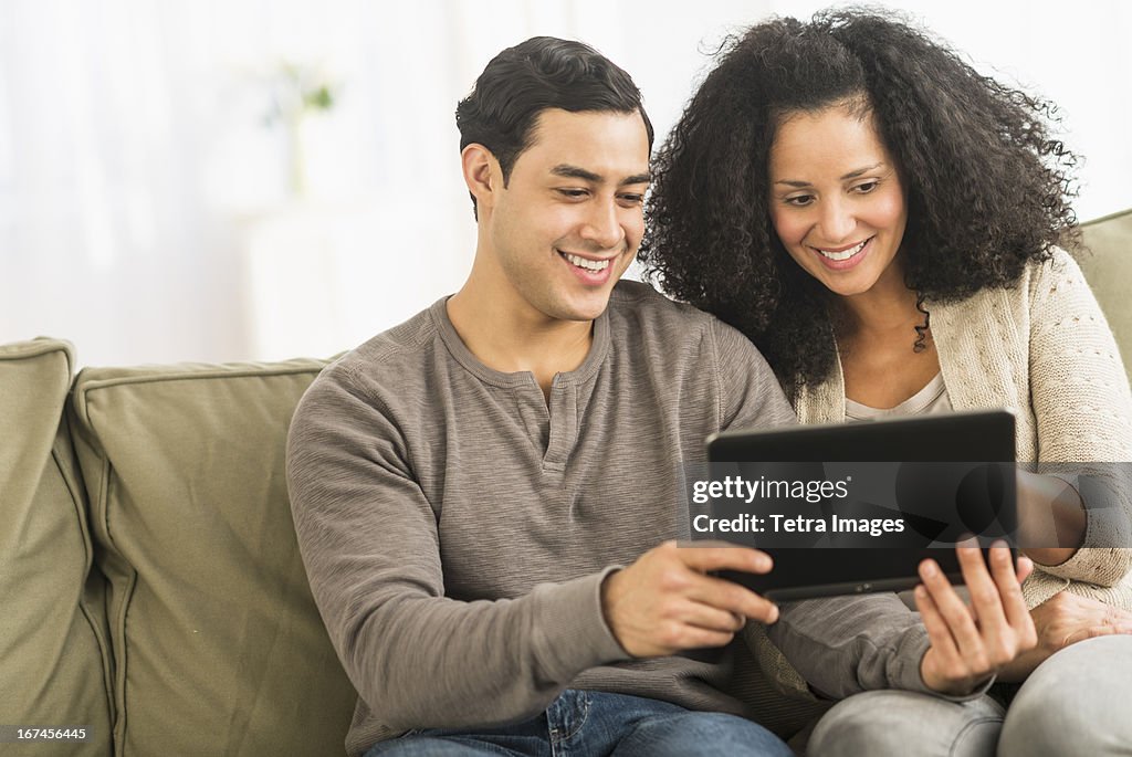 USA, New Jersey, Jersey City, Couple using digital tablet on sofa