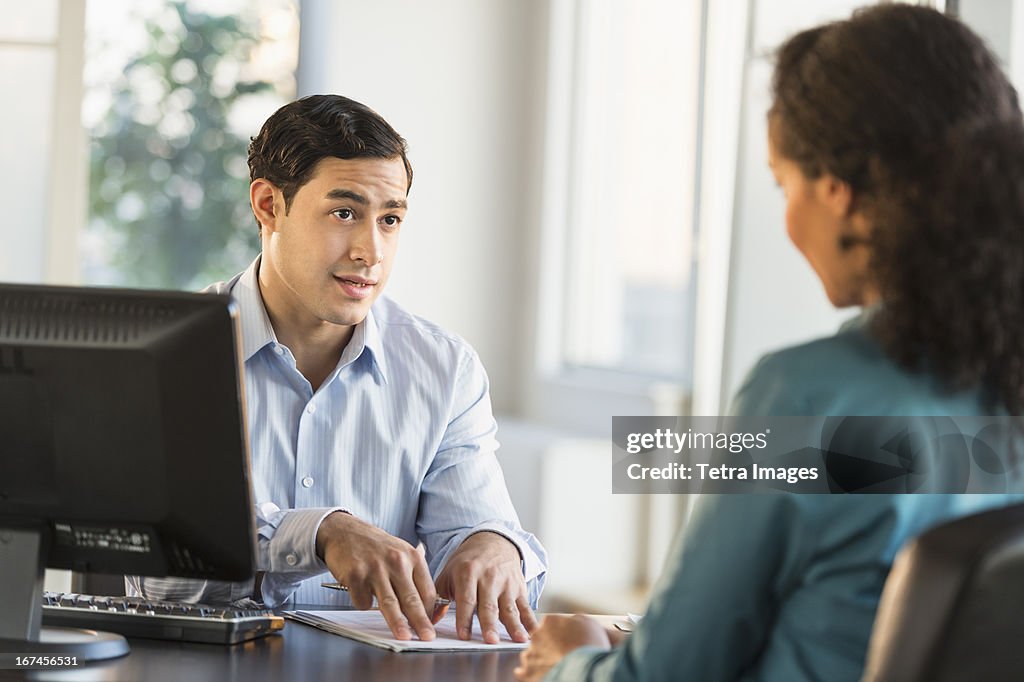 USA, New Jersey, Jersey City, Man and woman talking at desk during job interview