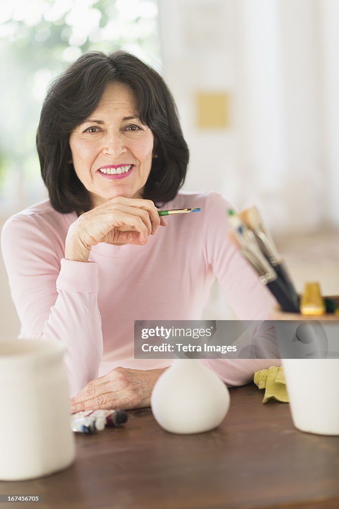 USA, New Jersey, Jersey City, Senior woman painting handmade pottery