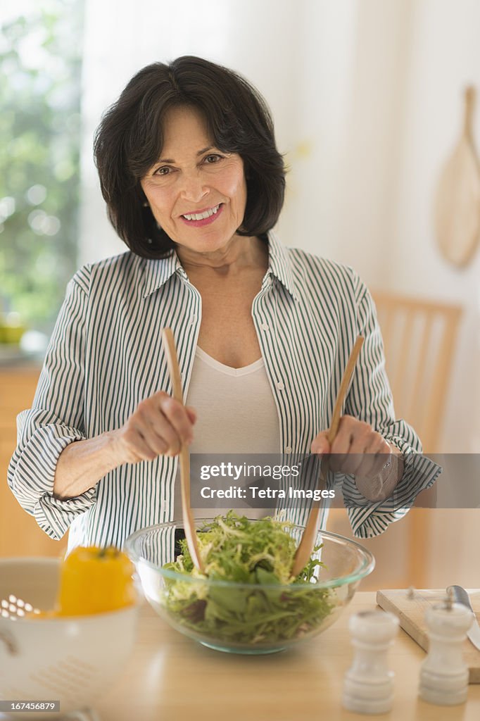 USA, New Jersey, Jersey City, Senior woman preparing salad