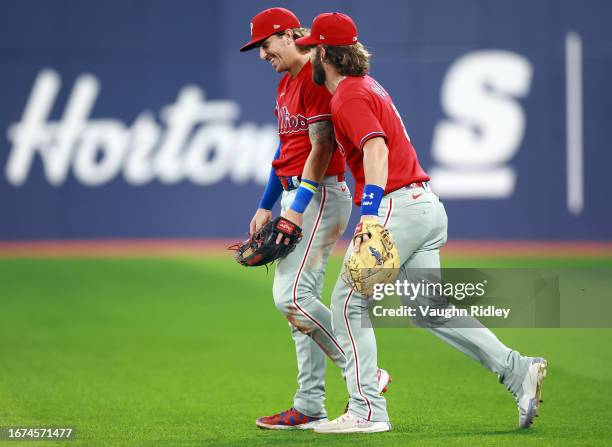 Bryson Stott and Bryce Harper of the Philadelphia Phillies share a laugh in the outfield during the seventh inning against the Toronto Blue Jays at...