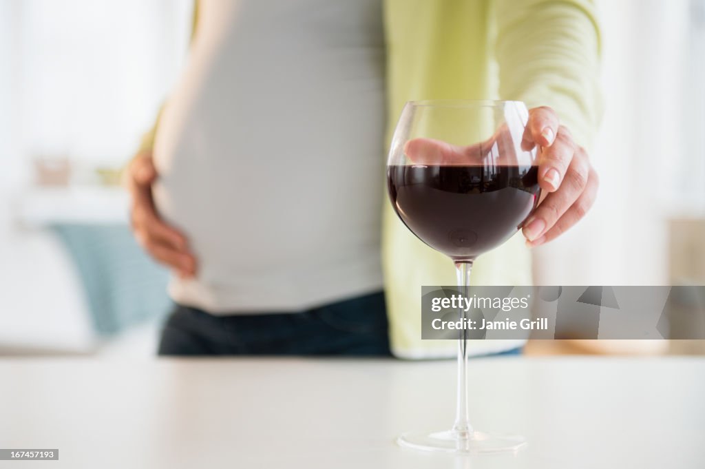 Pregnant woman with glass of red wine