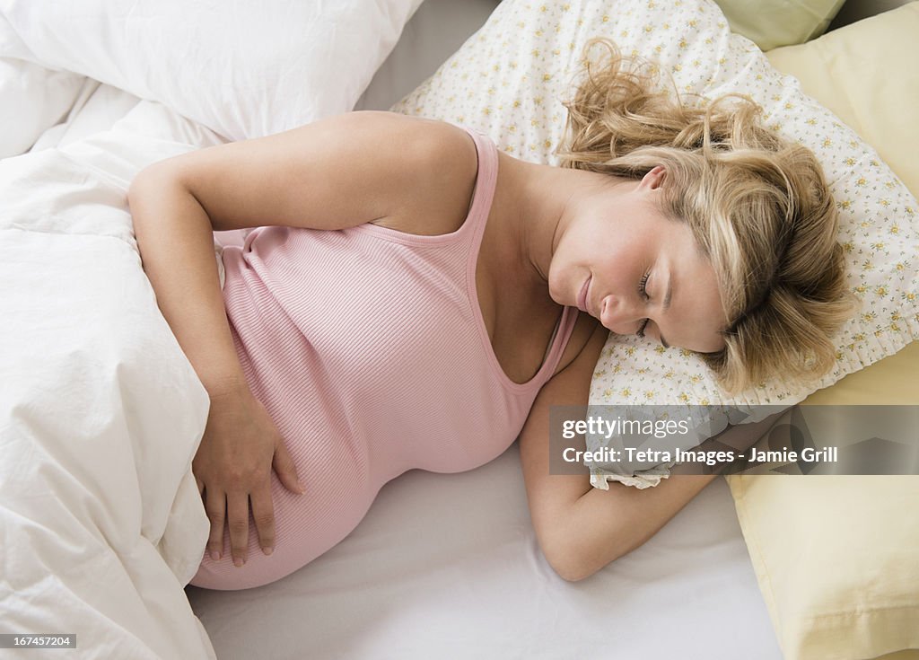 Pregnant woman asleep in bed