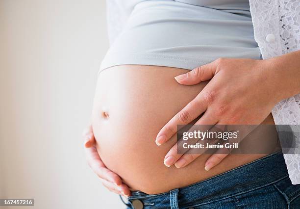 close-up of pregnant woman's belly - embarazada fotografías e imágenes de stock