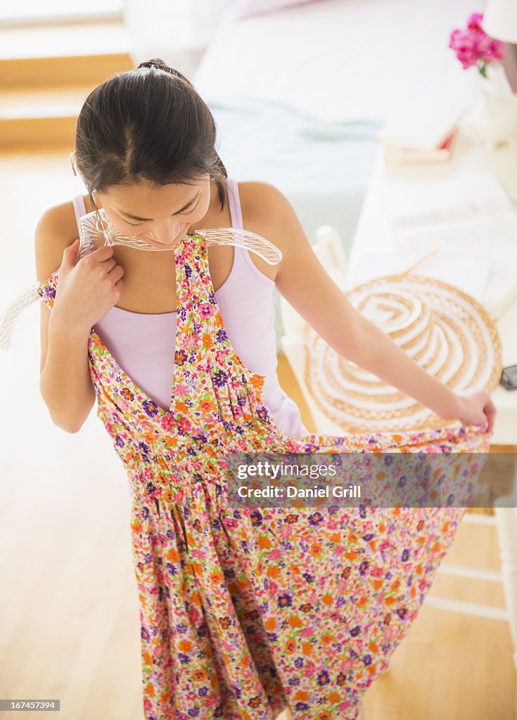USA, New Jersey, Jersey City, Front view of teenage girl ( 16-17 years) trying on dress
