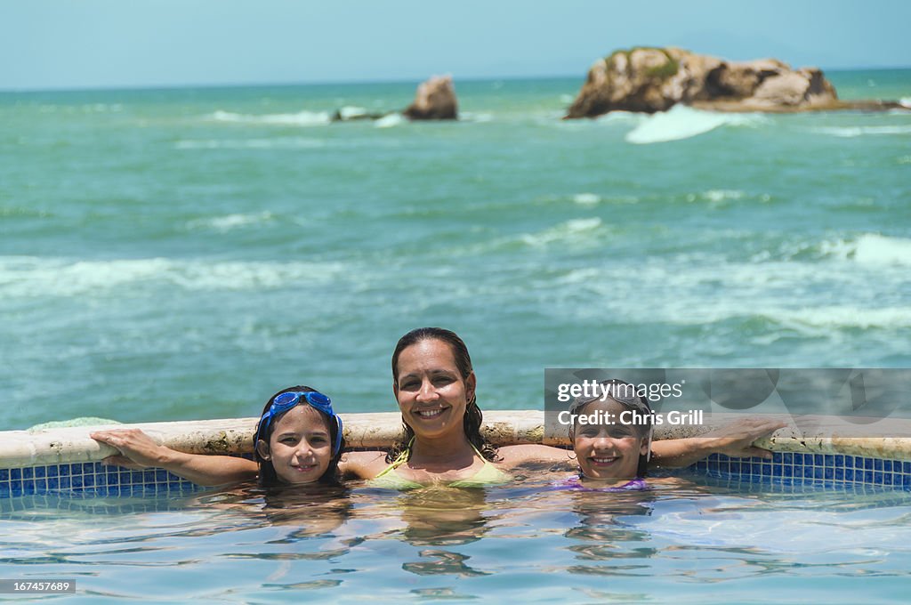 Puerto Rico, Humacao, Portrait of family in swimming pool (8-9 years) (10-11 years)