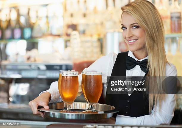 denmark, aarhus, portrait of young woman holding tray with beer glasses - 蝶ネクタイ ストックフォトと画像