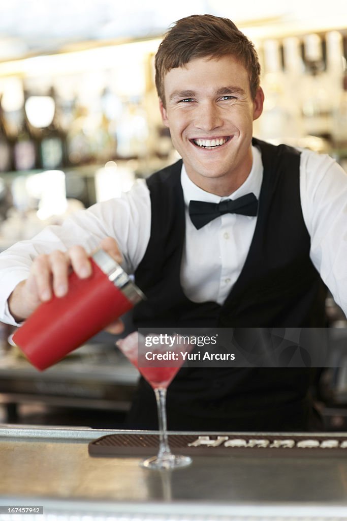 Denmark, Aarhus, Young bartender pouring cocktail 