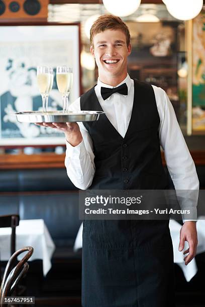 denmark, aarhus, portrait of waiter holding champagne flutes on tray - servitör bildbanksfoton och bilder