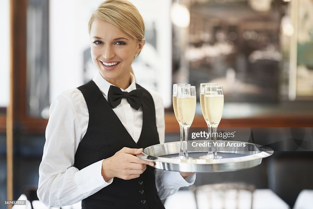 Denmark, Aarhus, Portrait of waitress holding champagne flutes on tray
