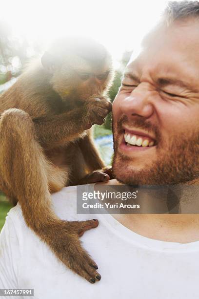 thailand, portrait of man holding monkey - primates stock pictures, royalty-free photos & images