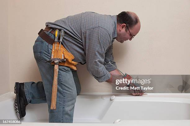 usa, texas, dallas, man with caulk gun working in bathroom - silikone stock pictures, royalty-free photos & images