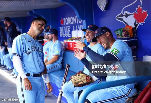 Whit Merrifield, Daulton Varsho and George Springer of the Toronto Blue Jays talk in the dugout prior to a game against the Philadelphia Phillies at...