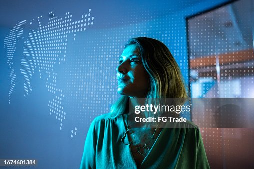 Mature businesswoman looking to a hologram at office Mature businesswoman looking to a hologram at office