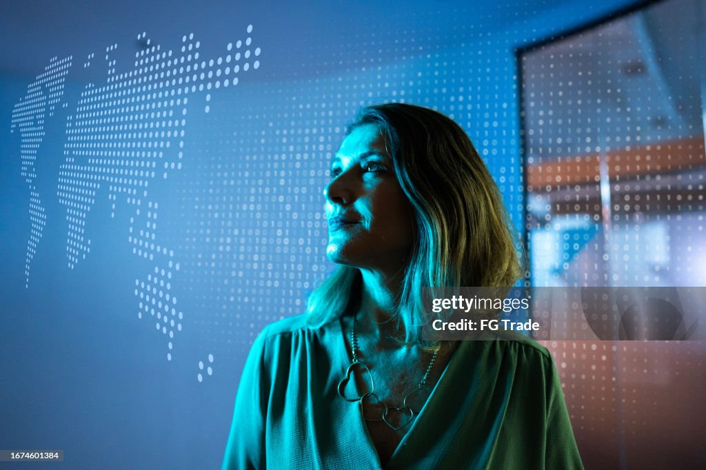 Mature businesswoman looking to a hologram at office