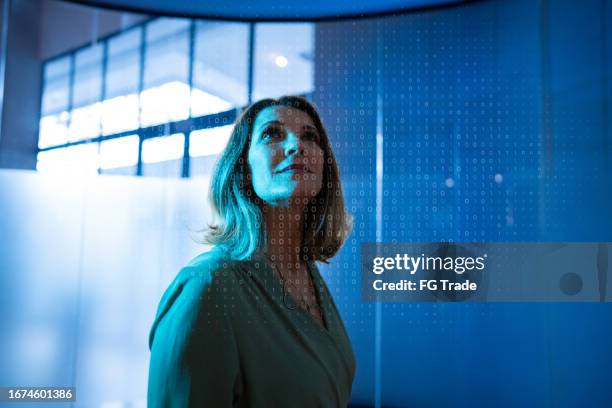 mature businesswoman looking to a hologram at office - compilations stock pictures, royalty-free photos & images