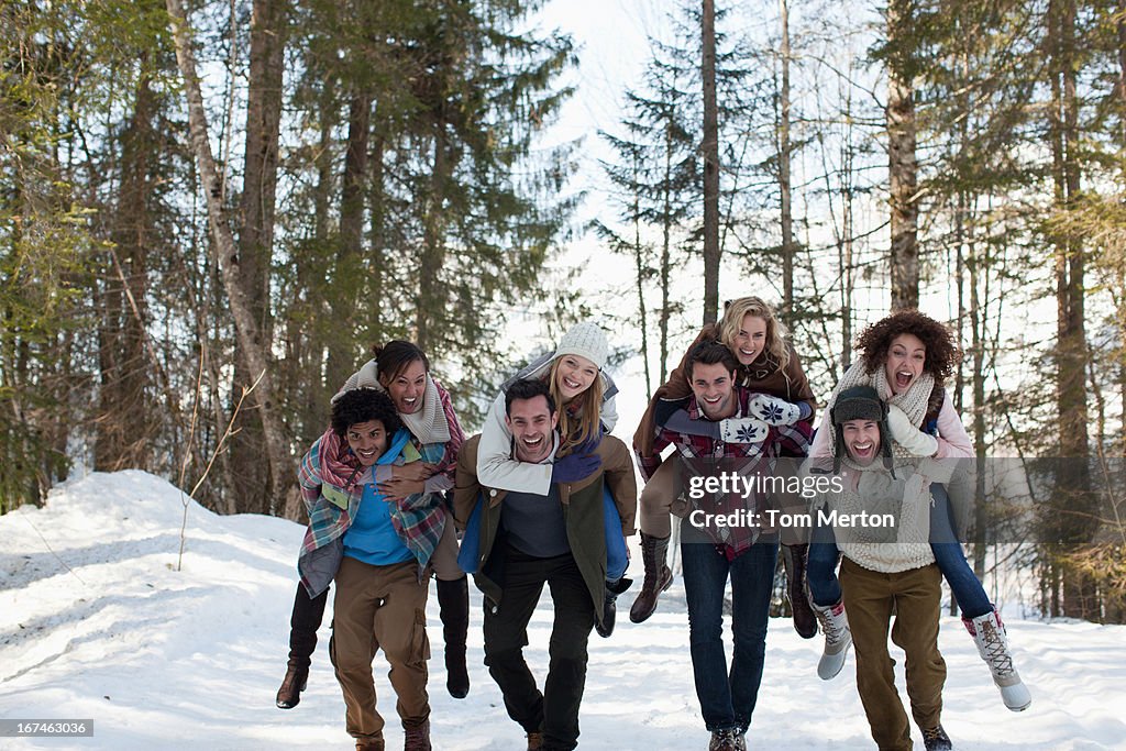 Souriant couple ferroutage à bois sous la neige