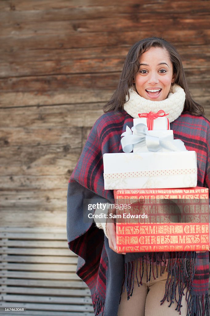 Portrait of smiling woman holding Christmas gifts