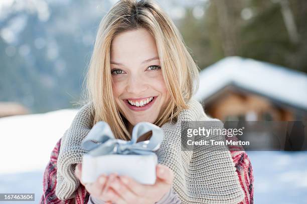 porträt der lächelnde frau hält weihnachtsgeschenk auf der vorderseite der kabine - frau geschenk stock-fotos und bilder