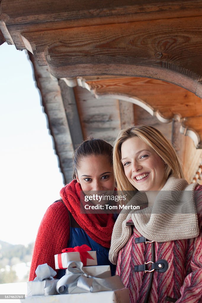 Two women with gifts outside cabin