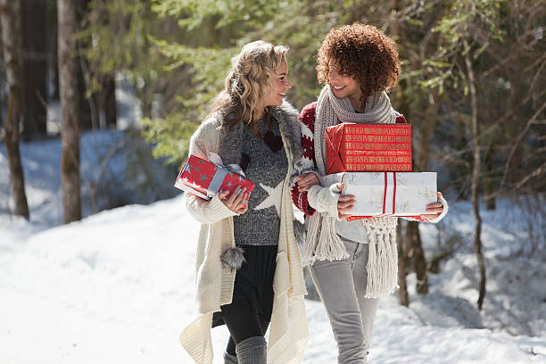 Two women carrying gifts outdoors in winter