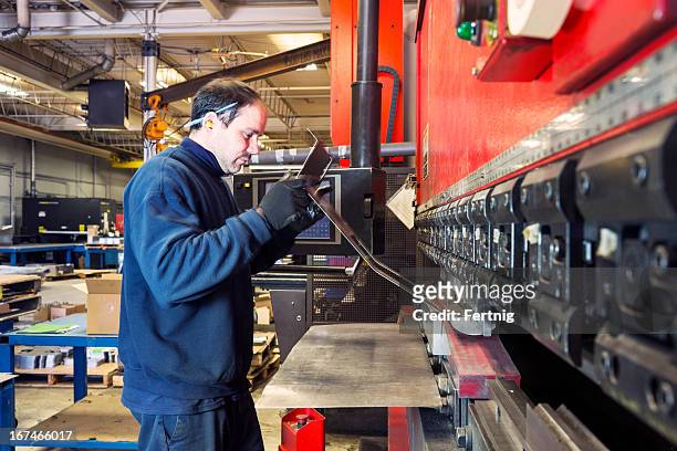brake press operator at work in a metalworking factory - sheet metal stock pictures, royalty-free photos & images
