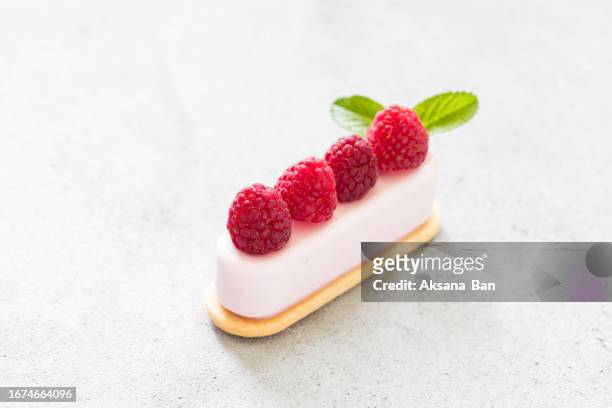 vanilla cream dessert on cookie, decorated with fresh raspberries. light grey background. close up - cream cake stock pictures, royalty-free photos & images