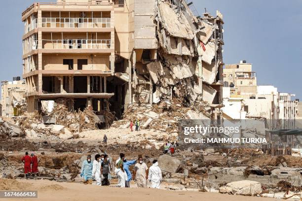 Rescue teams walk in a destroyed area in Libya's eastern city of Derna on September 18 following deadly flash floods. A week after a tsunami-sized...