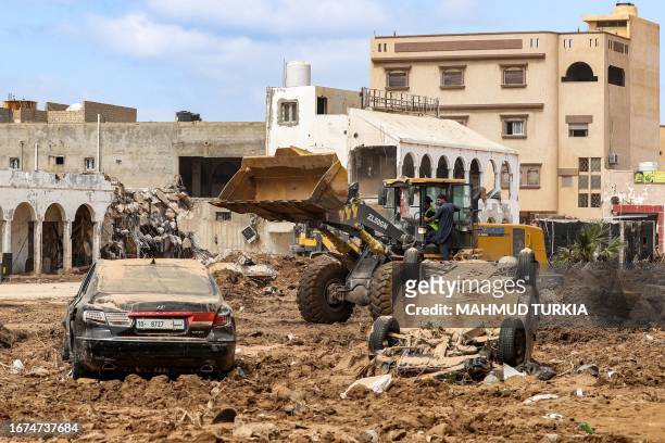 An excavator clears debris in Libya's eastern city of Derna on September 18 following deadly flash floods. A week after a tsunami-sized flash flood...