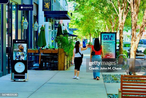 mosaic district, two women walking, fairfax, virginia (usa) - john street park stock pictures, royalty-free photos & images