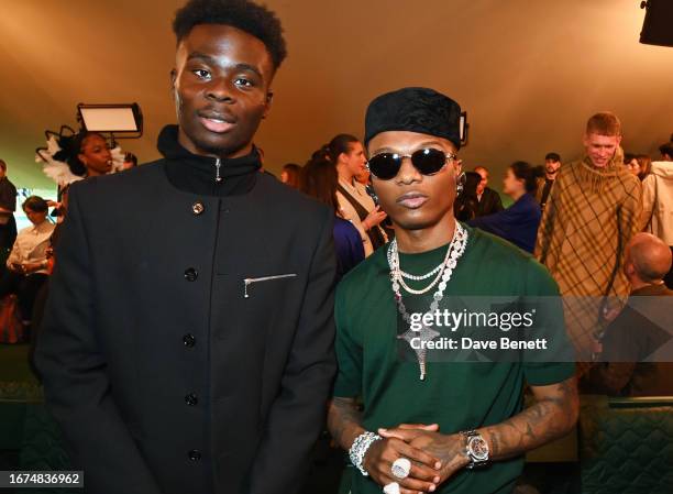 Bukayo Saka and Wizkid attend the Burberry Spring Summer 2024 show during London Fashion Week on September 18, 2023 in London, England.