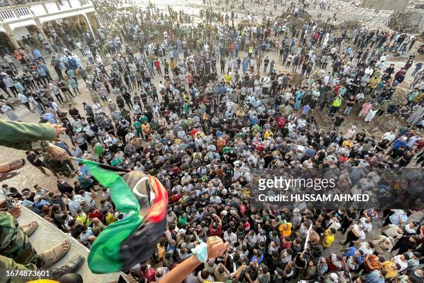 People gather for a demonstration outside the surviving Al-Sahaba mosque in Libya's eastern city of Derna on September 18 as they protest against...