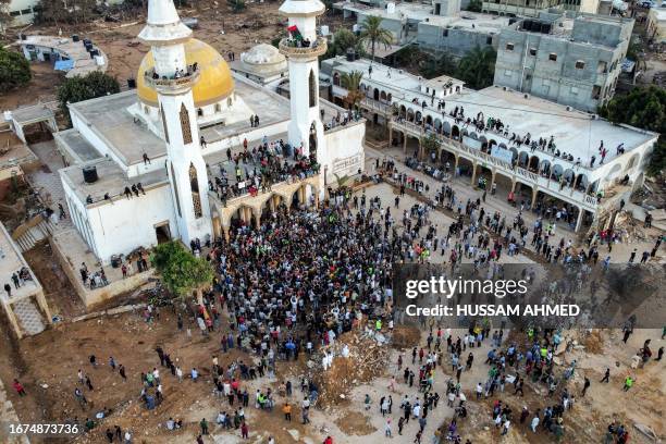 People gather for a demonstration outside the surviving Al-Sahaba mosque in Libya's eastern city of Derna on September 18 as they protest against...